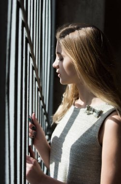 Güzel kız kapalı gözler ile metal korkuluk, ayakta