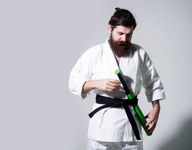kimono yeşil beysbol sopası ile gülümseyen karate erkekte sakallı