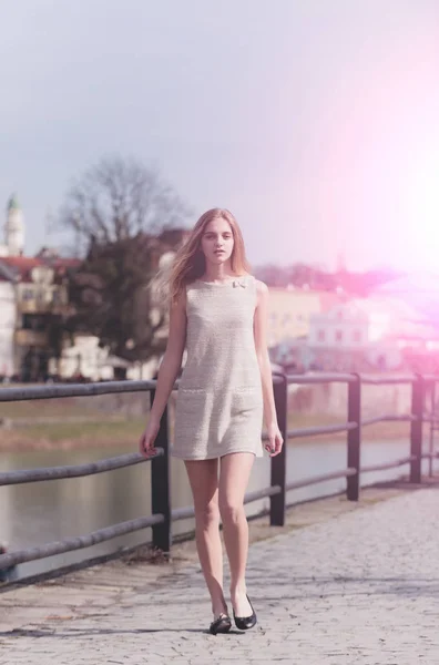 Menina bonita na moda vestido cinza andando no pavimento — Fotografia de Stock