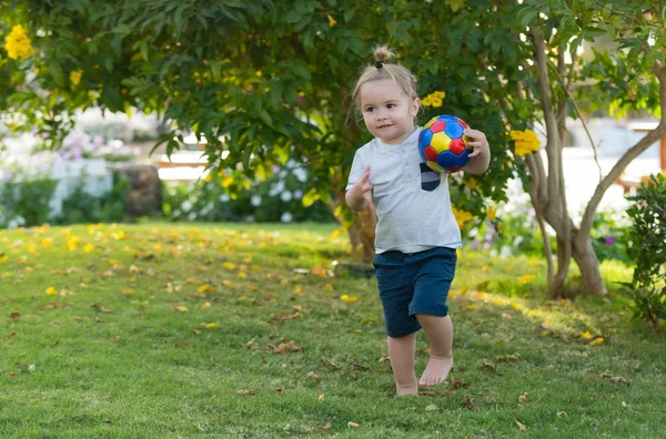 緑の草の上にボールで遊ぶかわいい男の子 — ストック写真