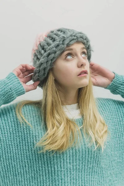 Όμορφη νεαρή κοπέλα με τα ξανθά μαλλιά σε μοντέρνο πουλόβερ, καπέλο — Φωτογραφία Αρχείου