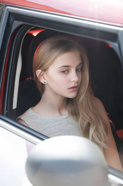Chica bonita con cara pensativa mirando a través de la ventana del coche —  Fotos de Stock