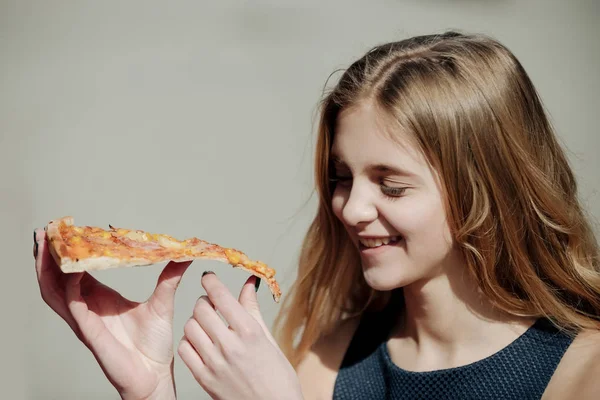 Feliz chica bonita sonriendo con un pedazo de pizza sabrosa — Foto de Stock