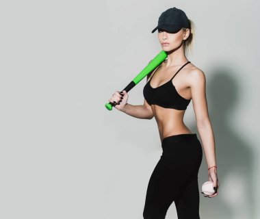 Oldukça sportif kız atlet oyuncu holding yeşil beyzbol sopası, top