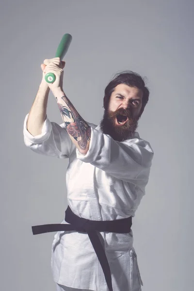 Skäggiga skriker karate man i kimono med gröna basebollträ — Stockfoto