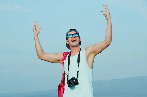 Un bel homme souriant, les mains levées vers le ciel bleu — Photo