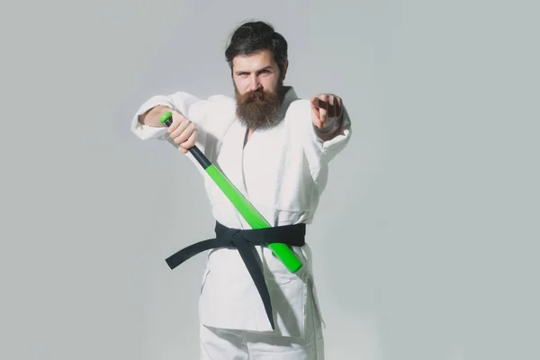 Skäggiga allvarliga karate man i kimono med gröna basebollträ — Stockfoto