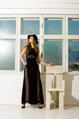 Şapka ve Giydir sandalye ve pencere güzel kız