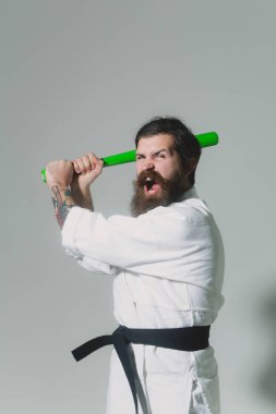kimono yeşil beysbol sopası ile erkekte karate bağırarak sakallı