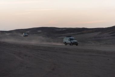 Kumul çöl yüzey üzerinde sürüş beyaz jip arabalar