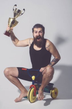 Sakallı mutlu adam Bisiklet oyuncak altın şampiyon Kupası tutar