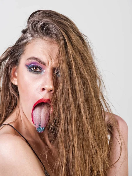 Beautiful girl with bright make up, fashionable hairstyle showing tongues — Stock Photo, Image