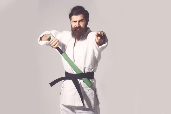 Bearded smiling karate man in kimono with green baseball bat — Stock Photo, Image