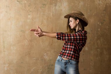 Parmak silah gösterilen şık kovboy şapkalı güzel kız