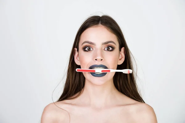 Chica con dientes frenos y cepillo, tiene maquillaje de moda — Foto de Stock