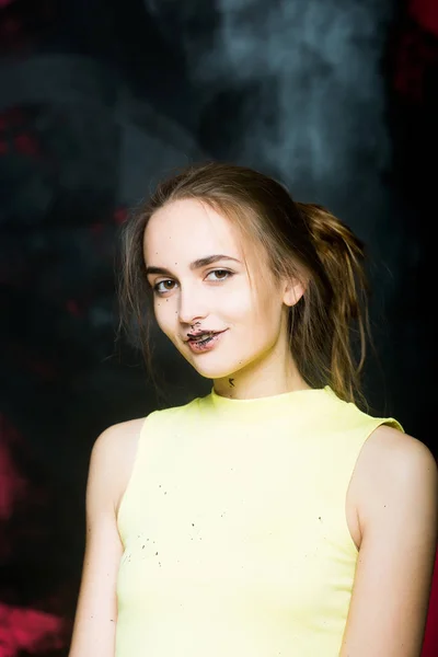 Досить брудна усміхнена дівчина-художник на пофарбованій стіні в чорний — стокове фото