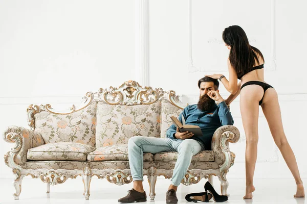 Uomo con donna sexy sul divano — Foto Stock