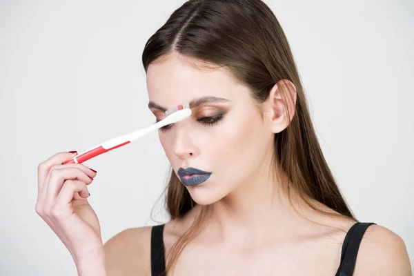 Menina com escova de dentes, tem maquiagem elegante — Fotografia de Stock