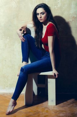 Kahverengi cups ile beyaz ahşap sandalye üzerinde oturan güzel kız