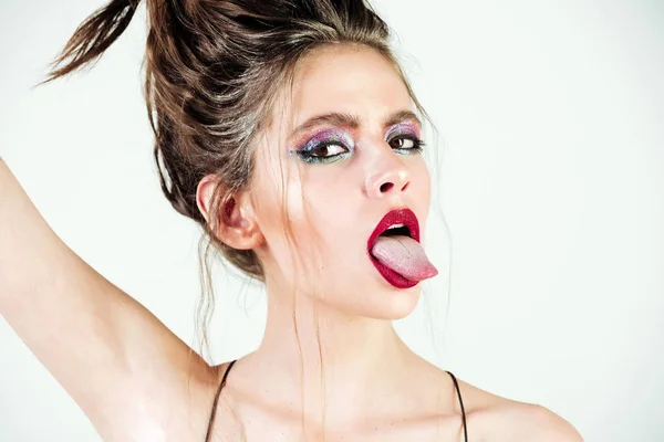 Beautiful girl with bright make up, fashionable hairstyle showing tongues — Stock Photo, Image
