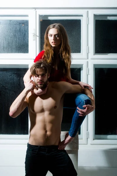 Hübsches Mädchen umarmt bärtigen Mann oder sexy Bodybuilder — Stockfoto
