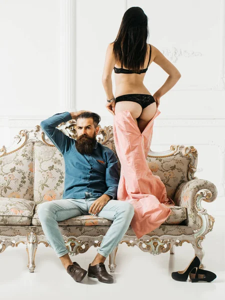 Uomo con donna sexy sul divano — Foto Stock
