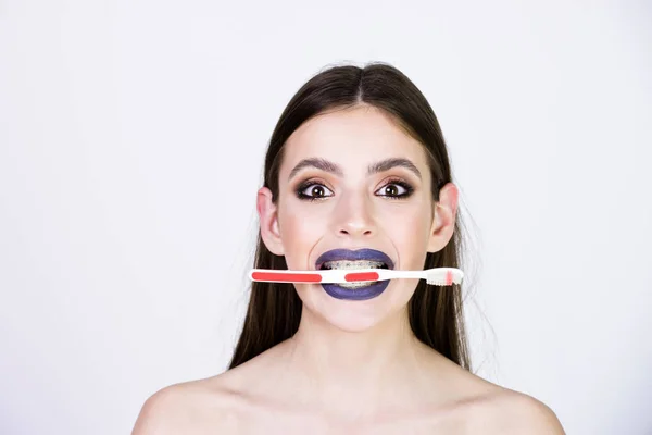 Meisje met tanden accolades en borstel, heeft modieuze make-up — Stockfoto
