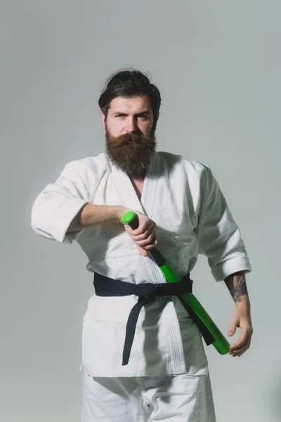 Skäggiga allvarliga karate man i kimono med gröna basebollträ — Stockfoto