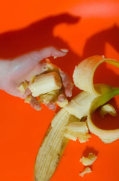 Weibliche Hand presst Saft oder Kürbis aus Banane — Stockfoto