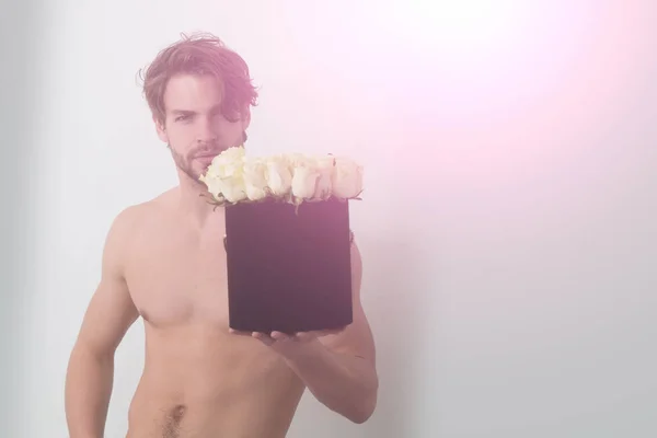 Muž s nahý trup držení růže v černé skříňky — Stock fotografie
