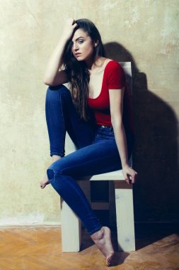 Güzel kız bacakları ile beyaz ahşap sandalye üzerinde oturan