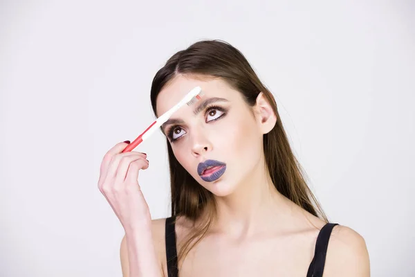 Menina com escova de dentes, tem maquiagem elegante — Fotografia de Stock