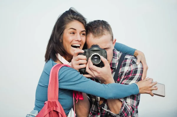 Excited girl hugging handsome man with camera — Stock Photo, Image