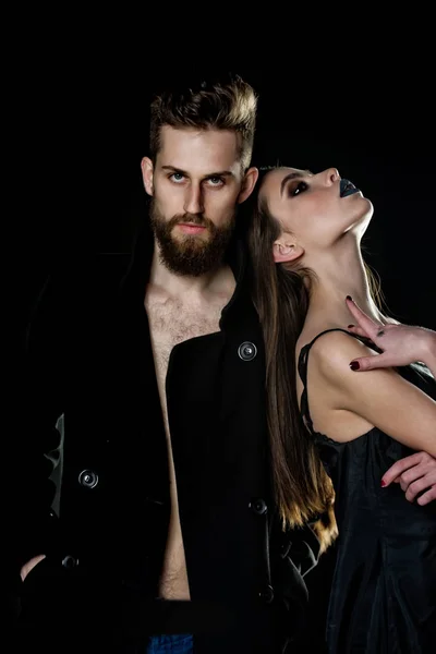 Пара бородатого чоловіка, жінка в чорному з модним макіяжем — стокове фото
