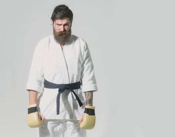 Bearded serious karate man in kimono and boxing gloves — Stock Photo, Image