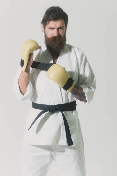 Bearded serious karate man in kimono and boxing gloves — Stock Photo, Image