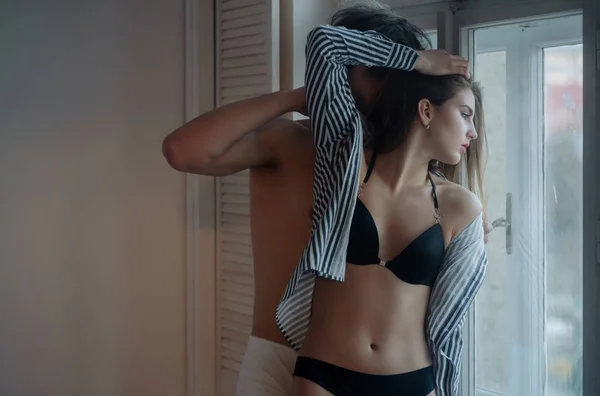 Chica quitandose la camiseta | mujer en ropa interior blanca quitándose