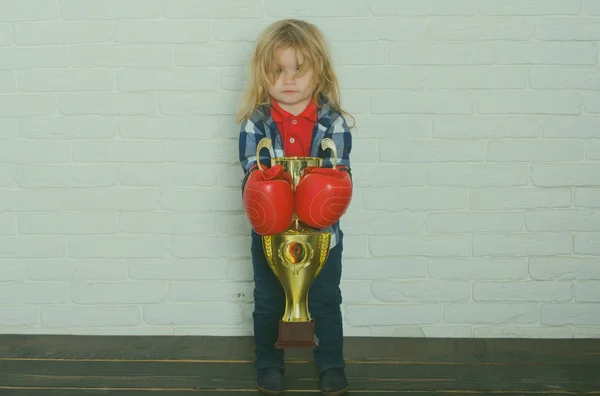Kid wearing boxing glove, boy boxer winning golden champion cup — Stock Photo, Image