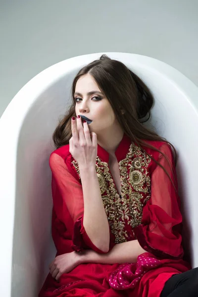Vrouw met rode jurk, lange haren, zwarte lippenstift in Bad — Stockfoto