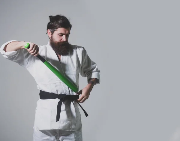 Bearded serious karate man in kimono with green baseball bat — Stock Photo, Image