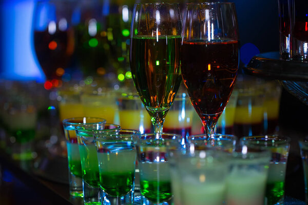 Glasses with alcoholic cocktails and layered shots