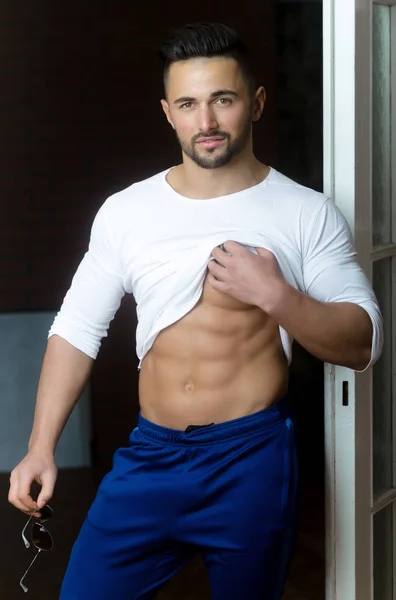 Sexy joven macho mostrando vientre muscular con seis paquetes —  Fotos de Stock