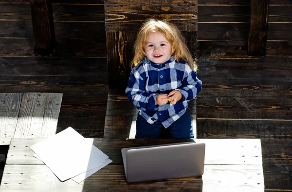 Feliz niño pequeño trabajo en la computadora con hoja de papel — Foto de Stock