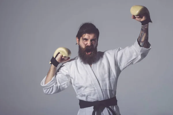 Bearded shouting happy karate man in kimono and boxing gloves — Stock Photo, Image