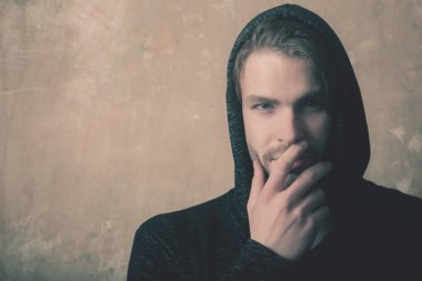 Beyaz adam tıraşsız yüzü gri kapüşonlu el ile gizleme