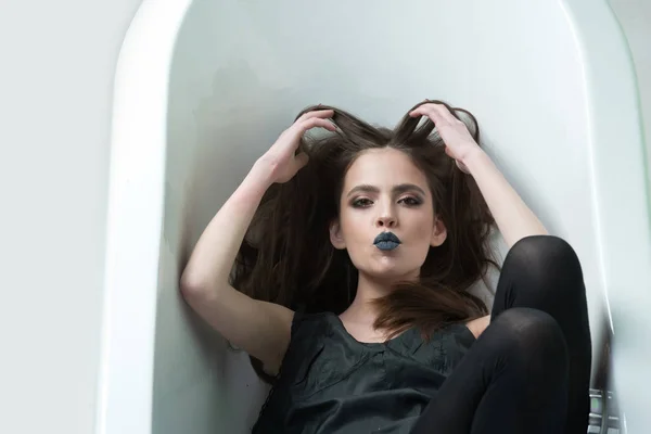 Vrouw in jurk met lang haar, zwarte lippenstift in bad — Stockfoto