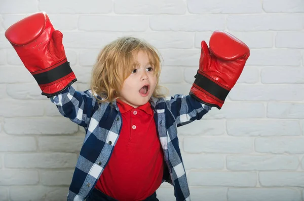 champion or happy small boy in red boxing gloves, winning