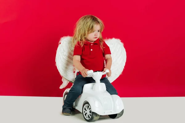 Ángel chico para San Valentín saludo, hermoso cupido en coche juguete — Foto de Stock