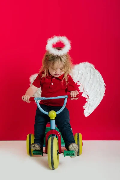 天使バイクで赤背景に小さな男の子 — ストック写真