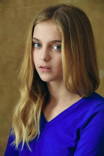 Pretty girl with long blonde hair in blue jersey — Stock Photo, Image